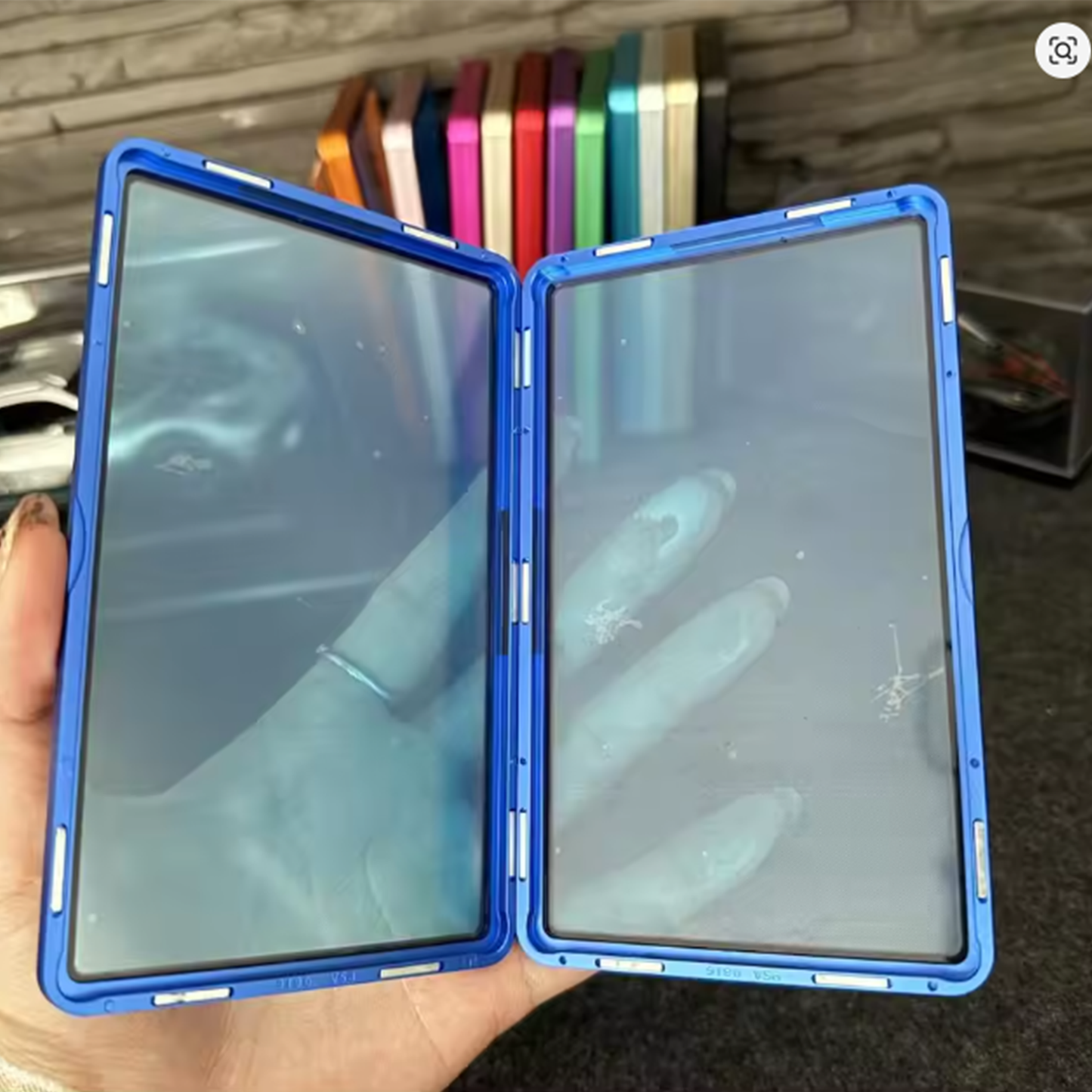 Blue phone case held open to show interior design, with a blurred background.