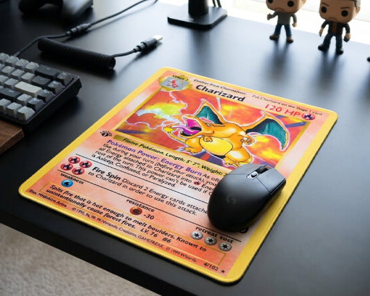Classic Charizard Pokémon trading card style mouse pad with black wireless gaming mouse on a modern dark desk setup with collectible figures