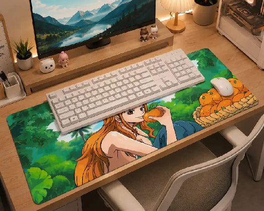 A large desk mat with a colorful anime-style illustration sits on a wooden desk, styled with a white keyboard and mouse. The desk setup is shown in a warm, cozy room environment with a monitor, lamp, and chair.