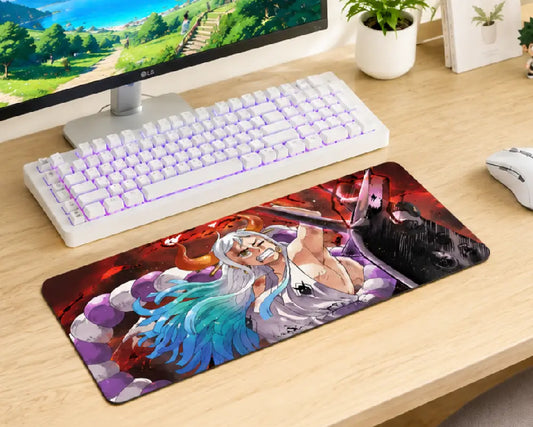 A large rectangular gaming desk mat with a colorful anime-style illustration, shown on a light wood desk next to a white keyboard and mouse.