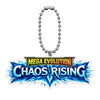 A Mega Evolution Perfect Order keychain with a silver clasp, resting on a wooden desk next to a keyboard, notebook, and plant.