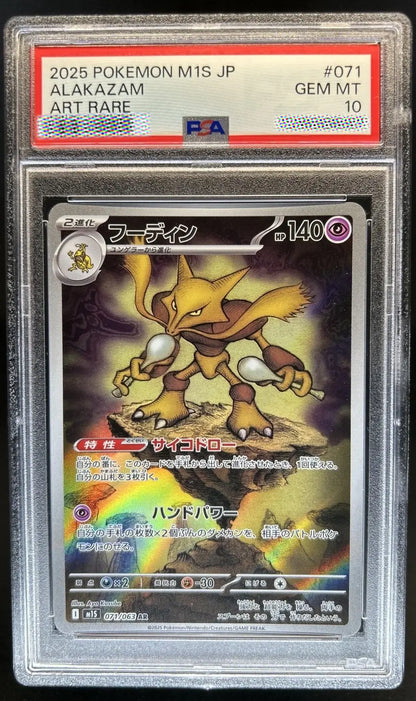 A graded Pokémon trading card of Alakazam from the 2025 M15 JP set, encapsulated in a PSA Gem Mint 10 holder. The card features Alakazam with a holographic rainbow effect, and the PSA grading label is visible at the top.