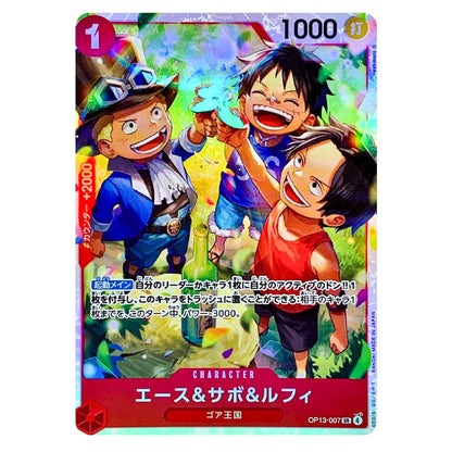 A Japanese character trading card featuring the anime characters Ace, Sabo, and Luffy from One Piece. The card has a red border, Japanese text, and a colorful illustration with a gold foil sheen.