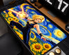 A large desk mat featuring an anime-style illustration of a blonde female character in a black bodysuit with a glowing yellow sword, set against a swirling blue and yellow sunflower background. The desk mat is styled on a dark desk with a monitor, speakers, and other office accessories.