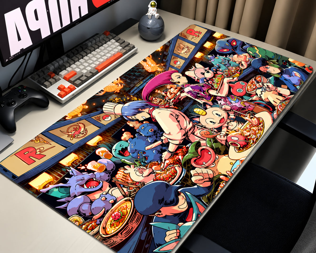 A large rectangular desk mat featuring a highly detailed, colorful anime-style illustration of characters from Street Fighter, displayed on a light gray desk next to a keyboard, controller, and monitor.