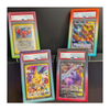 Four trading cards in protective cases with visible grading labels on a dark background