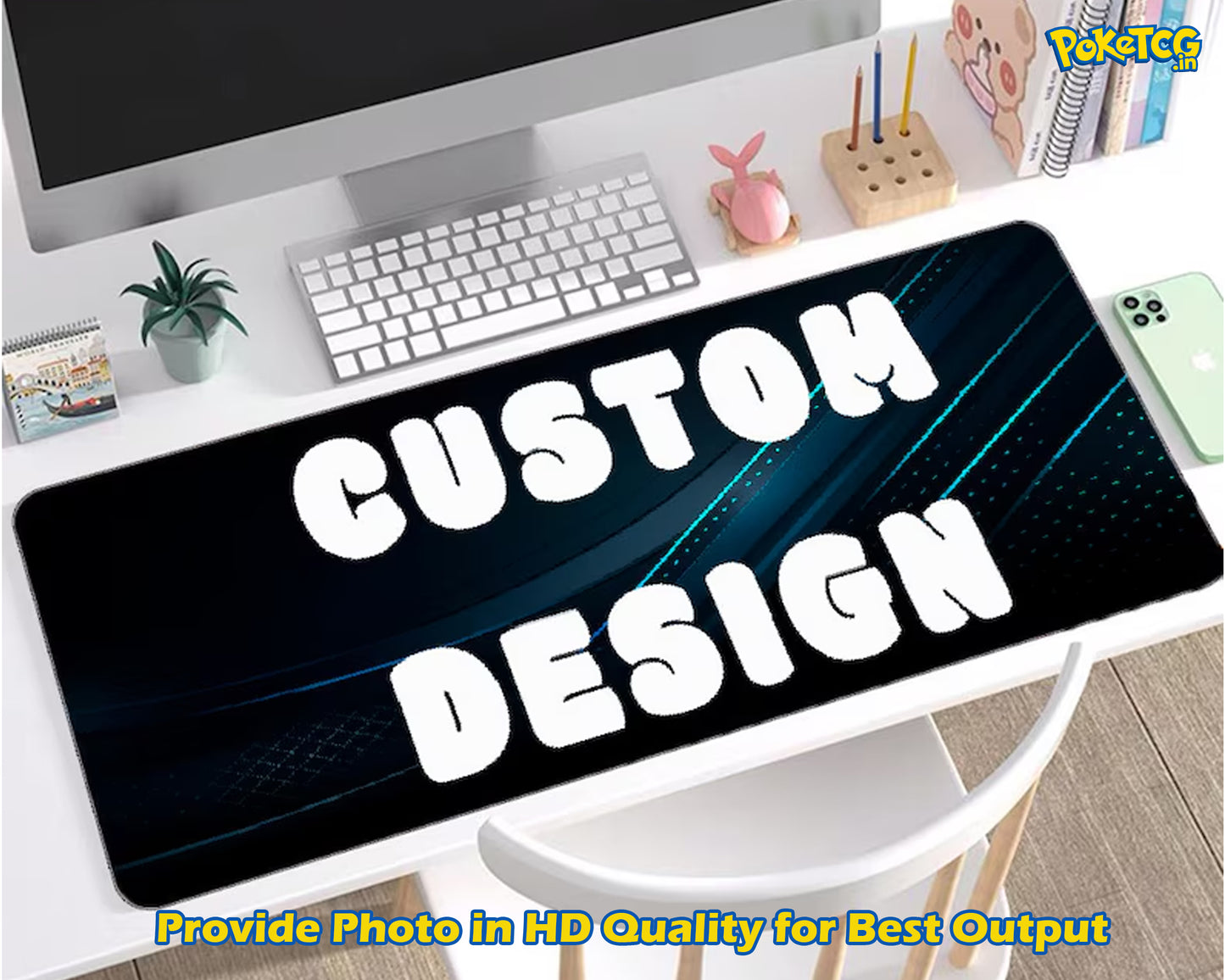 A large desk mat with a customizable black and blue graphic design featuring bold white text reading 'CUSTOM DESIGN', displayed on a white desk with a keyboard, monitor, and small plant in the background.
