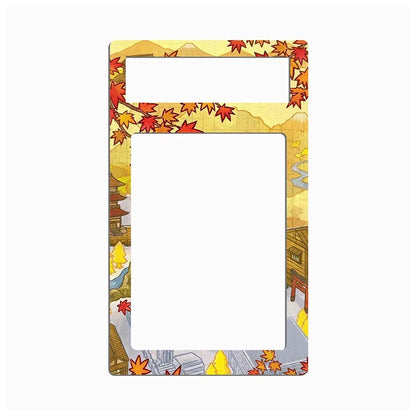 A rectangular picture frame with rounded corners, featuring a Japanese autumn landscape illustration with red maple leaves, mountains, and traditional buildings around the border. The center is blank white, and there is a small horizontal slot at the top.