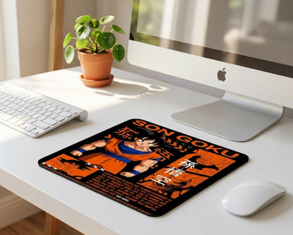 Son Goku anime inspired mouse pad with bold orange and black design placed on a clean white desk setup featuring iMac, wireless keyboard, mouse, and small indoor plant