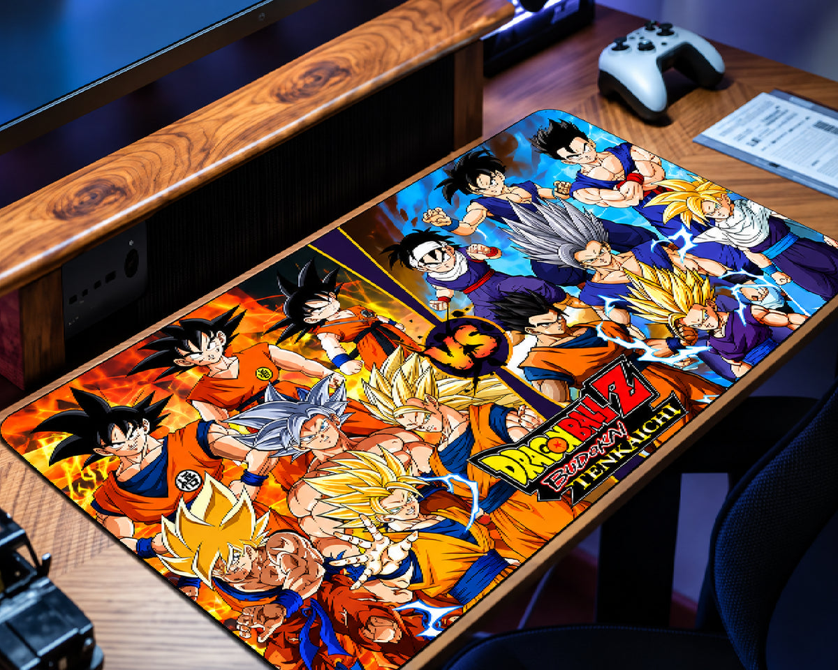 Dragon Ball Z Goku extended gaming mouse pad featuring a colorful collage of Goku in classic orange outfits, golden Super Saiyan forms, and silver-haired transformations, with orange flames and blue lightning, displayed on a wooden gaming desk.