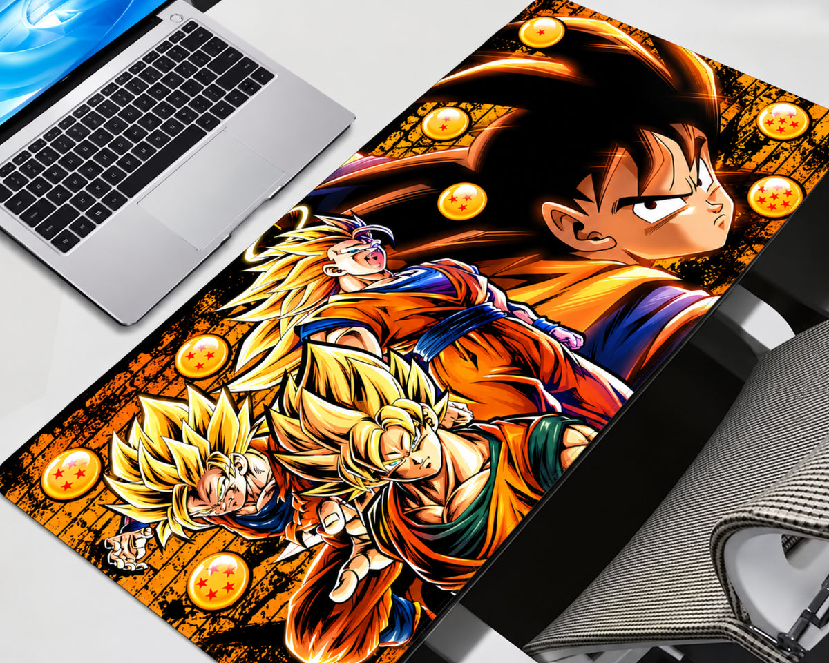 A large desk mat featuring a colorful Dragon Ball Z anime print with Goku, Vegeta, and Son Goku, styled on a desk next to a laptop and keyboard.