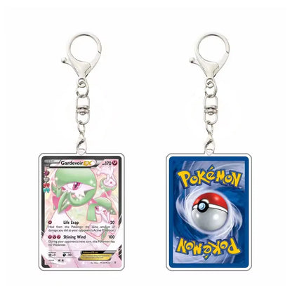 Two Pokémon acrylic keychains shown side by side on a white background. The left keychain features a Gardevoir EX card, and the right keychain features a blue Pokémon card with a Pokéball and the yellow Pokémon logo.