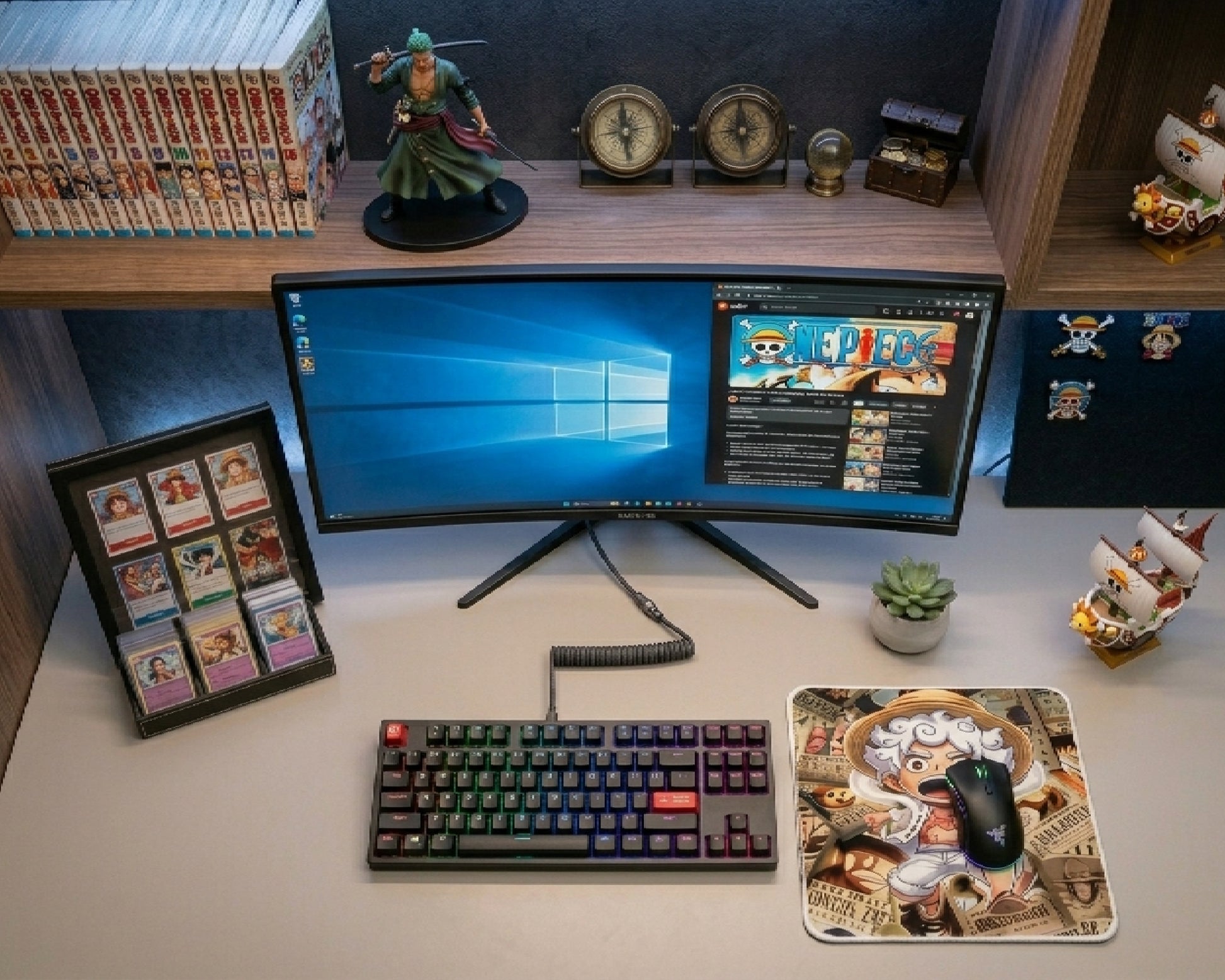 Modern One Piece anime gaming setup featuring Gear 5 Luffy themed mouse pad, RGB mechanical keyboard, ultrawide monitor, manga collectibles, and clean desktop workspace aesthetic