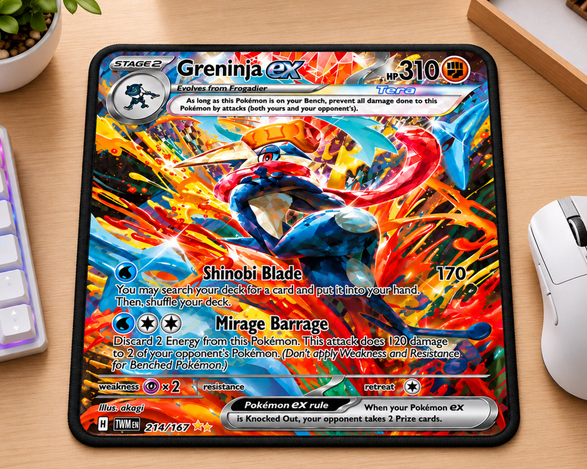 A rectangular desk mat featuring the Greninja EX card artwork from Pokémon, placed on a wooden desk next to a keyboard, mouse, and small plant.