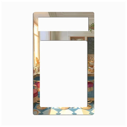 A rectangular picture frame with rounded corners, featuring a printed illustration of a cozy cafe interior with blue chairs, warm sunlight, and a patterned floor. The center of the frame is blank white, and there is a small horizontal slot at the top.