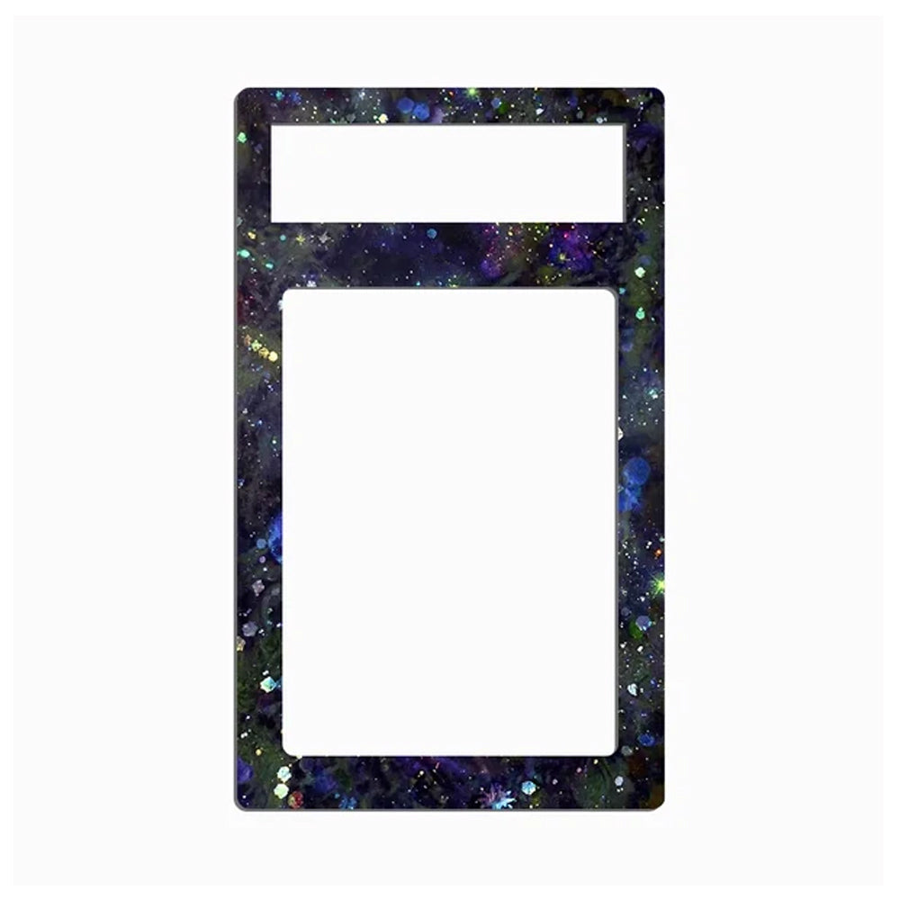 A rectangular decorative frame or plate with rounded corners, featuring a dark galaxy print with purple, blue, green, and gold glitter speckles. The top section has a smaller horizontal slot, and the lower section is a larger vertical slot, both filled with a solid white insert, set against a plain white background.