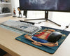 One Piece Luffy anime gaming mouse pad with seated character artwork beside white mechanical keyboard and gaming monitor setup
