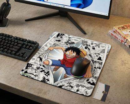 Monkey D. Luffy manga action mouse pad with black-and-white comic panel background, RGB gaming mouse, mechanical keyboard, and modern desktop setup