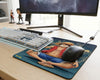 One Piece Luffy anime gaming mouse pad placed under white mechanical keyboard and black gaming mouse on wooden desk