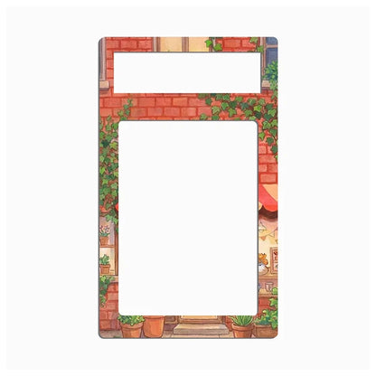 A rectangular picture frame with a decorative illustration of a brick wall, green ivy, potted plants, and a small storefront scene, shown on a plain white background.