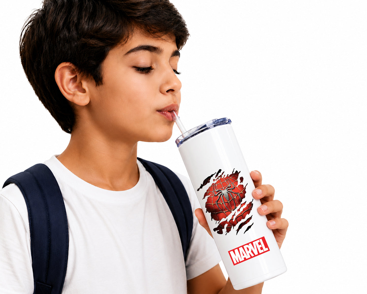 A young boy with short dark hair, wearing a white t-shirt and a navy backpack, holds a white Marvel-branded tumbler with a Spider-Man graphic while drinking from a straw against a white background.
