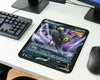 Close-up gaming desk featuring Umbreon Noctali V Pokémon themed mouse pad, compact RGB keyboard, dual monitor setup, and modern wireless gaming mouse