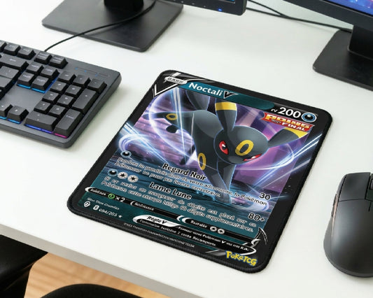 Close-up gaming desk featuring Umbreon Noctali V Pokémon themed mouse pad, compact RGB keyboard, dual monitor setup, and modern wireless gaming mouse