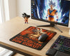 Minimal wooden desk gaming setup featuring Ultra Instinct Son Goku anime mouse pad, RGB mechanical keyboard, gaming mouse, widescreen monitor, and Dragon Ball character figure
