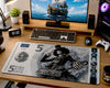 A large desk mat featuring the One Piece Brook the Skeleton card design, styled on a wooden desk alongside a keyboard, mouse, speakers, monitor, and gaming accessories.