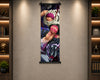 A vertical anime wall scroll featuring characters from One Piece, hanging on a textured beige wall between two illuminated wooden shelves with books and decor.