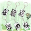 Six rectangular acrylic keychains with silver metal key rings and chains, each featuring black-and-white manga-style character illustrations, arranged on a pale green background with a white flower graphic.