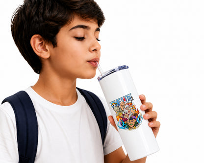A young boy with a white t-shirt and dark backpack straps holds a white insulated tumbler with a colorful cartoon graphic and a clear lid while drinking from a straw against a white background.