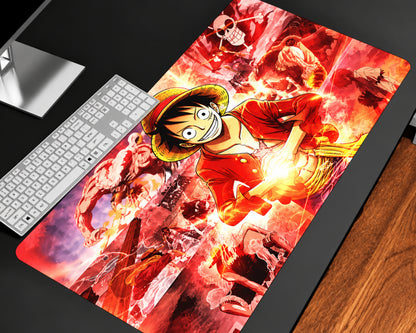 One Piece Luffy extended gaming mouse pad featuring Monkey D. Luffy wearing a straw hat and red outfit, surrounded by fiery red and orange effects, glowing golden energy, and action-packed anime character artwork, displayed on a black desk beside a white keyboard.