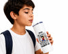 A boy with short dark hair, wearing a white t-shirt and a navy backpack strap, holds a white insulated travel tumbler with a straw. The tumbler features a black and white comic book style graphic of a character with the text 'ONE PIECE' on a clean white background.