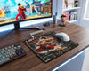 One Piece Luffy-Tarou anime gaming mouse pad on wooden desk beside RGB keyboard, white gaming mouse, and anime-themed monitor setup