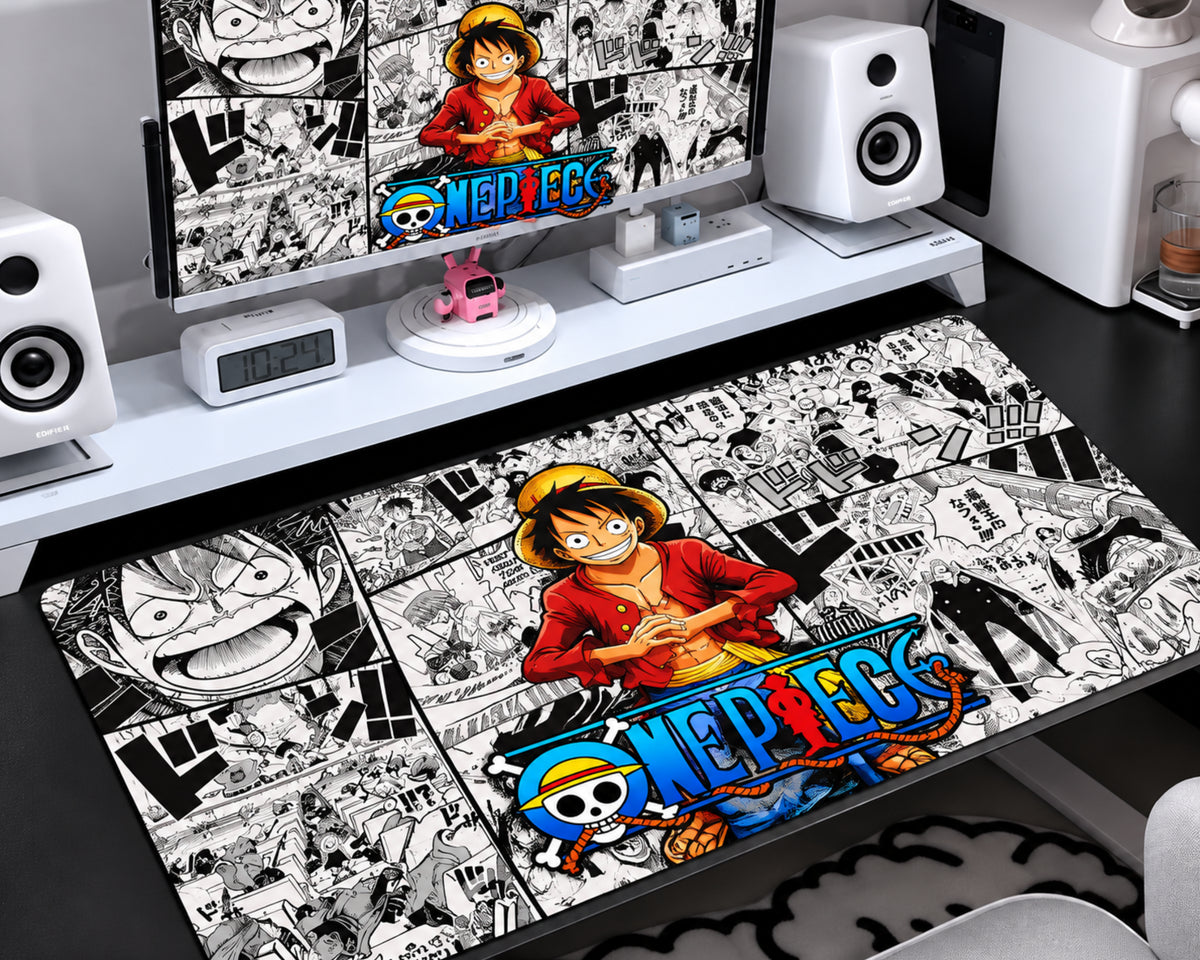 Gaming mouse pad featuring a smiling straw-hat anime pirate in a red outfit, colorful blue-and-yellow lettering, and a detailed black-and-white manga panel collage.