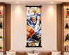 A vertical anime wall scroll featuring a dynamic illustrated character in a white coat, displayed hanging on a beige wall above a sofa in a styled living room with shelving and decorative figurines.
