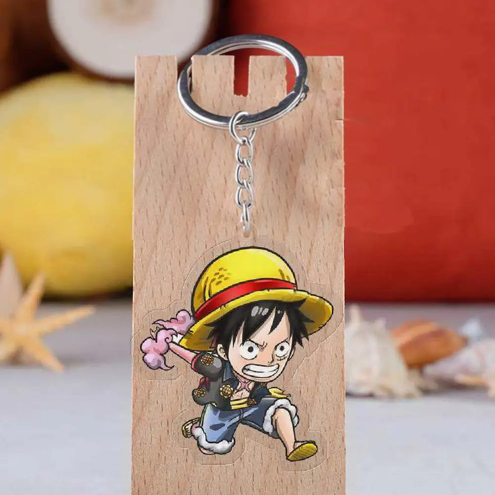 A cartoon keychain featuring the character Monkey D. Luffy from One Piece, mounted on a rectangular wooden block with a silver metal key ring and chain.