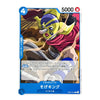 A single collectible trading card featuring an illustrated fantasy character with green skin, a purple headpiece, and a red scarf, shown on a plain white background. The card includes blue corner icons, Japanese text, and a blue bottom banner.