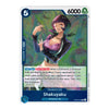 A single trading card featuring the character Shakuyaku, Amazon Lily, with illustrated artwork of a woman in a purple outfit against a green and blue abstract background. The card has a white border, blue header and footer, a counter of 5, a power of 6000, and text boxes for game effects.