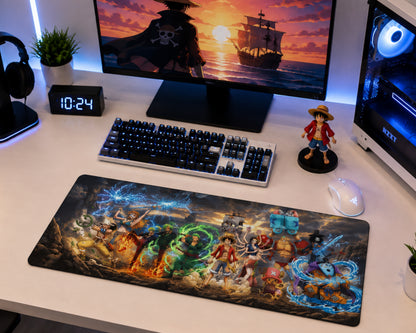 A large gaming desk mat featuring detailed anime artwork from One Piece, displayed on a white desk alongside a keyboard, mouse, monitor, and small figurine.