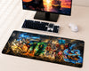A large rectangular gaming desk mat featuring a colorful anime battle scene with multiple characters, shown on a light wood desk next to a keyboard, mouse, and monitor.