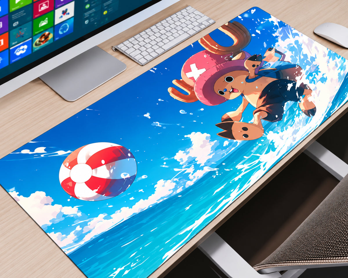 A large desk mat featuring a colorful anime-style print of a character flying over blue ocean waves with a red-and-white striped ball, shown on a wooden desk next to a computer monitor, keyboard, and mouse.