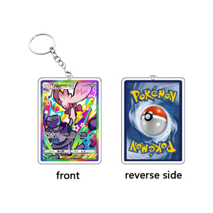 A Pokémon Trailor keychain shown from both sides on a plain white background. The front side features a colorful holographic Pokémon card illustration, and the reverse side shows the blue Pokémon card back with a central ball graphic and yellow Pokémon branding.