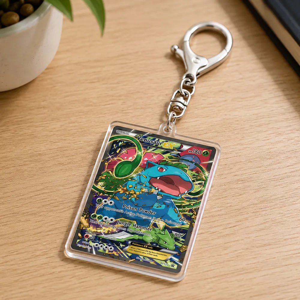A Pokémon TCG acrylic keychain featuring a colorful Charizard card design, attached to a silver metal lobster clasp, resting on a light wood desk.
