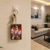 A Pokémon TCG character card holder with keys attached, mounted on a beige wall in a modern living room setting.