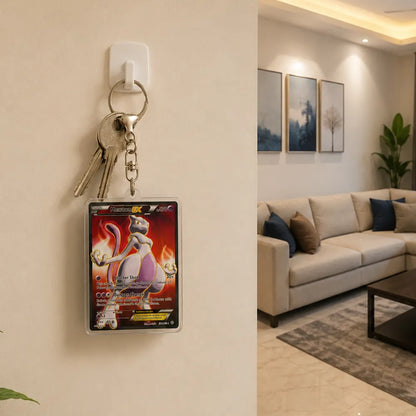 A Pokémon TCG character card holder with keys attached, mounted on a beige wall in a modern living room setting.