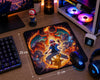 A large rectangular gaming desk mat with a colorful Pokémon artwork print, shown on a wooden desk with a keyboard, mouse, headphones, monitor, and PC case around it. White dimension lines indicate 25 cm by 21 cm.