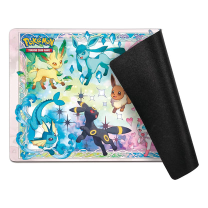 Pokémon Trading Card Game playmat featuring colorful artwork of Eevee and other Eevei family Pokémon, with a black textured backing sheet partially peeled off on the right, shown on a white background.