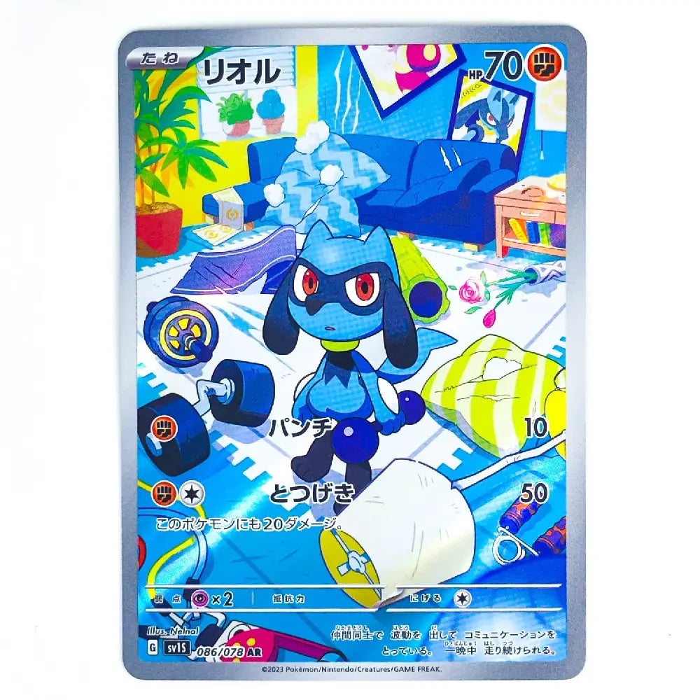 A Pokémon trading card featuring the blue character Riolu in a colorful living room, with Japanese text and game stats visible on the card.
